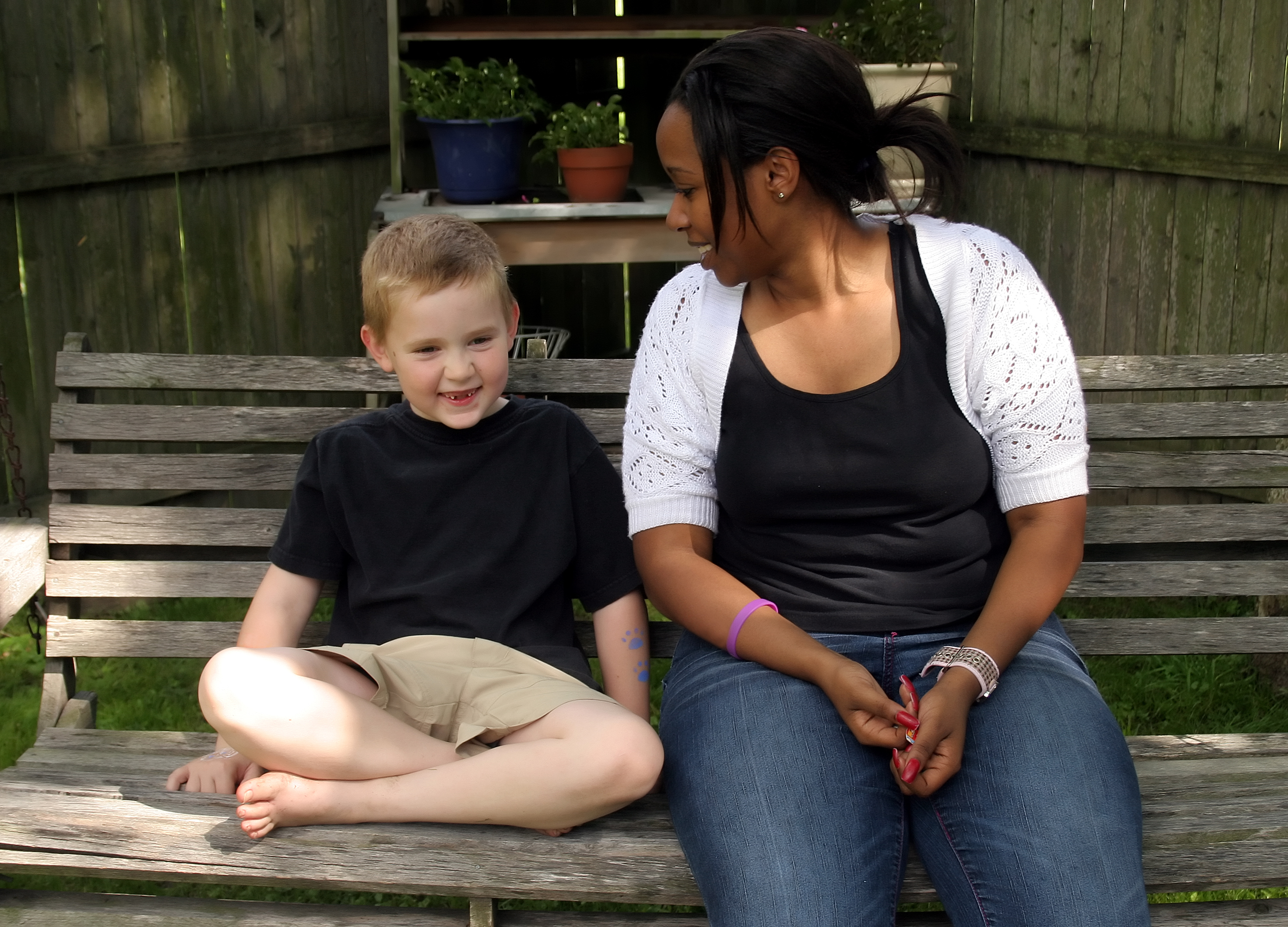 PIC - Woman and young child sitting on a garden bench