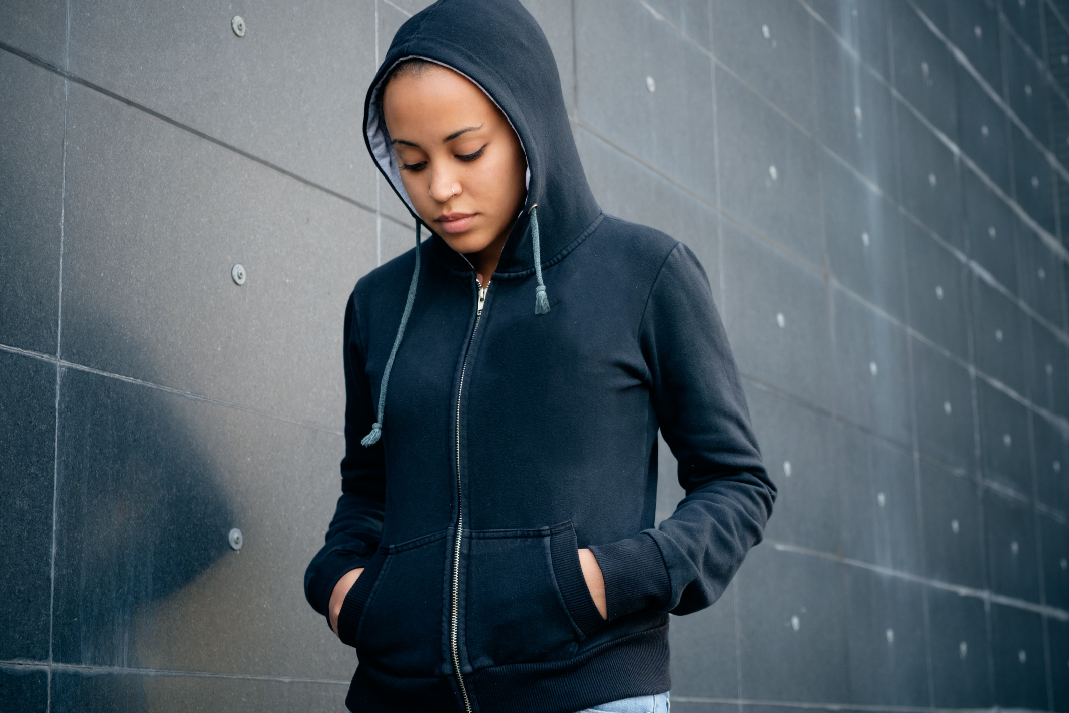 pic - hooded teenage girl looking towards the ground