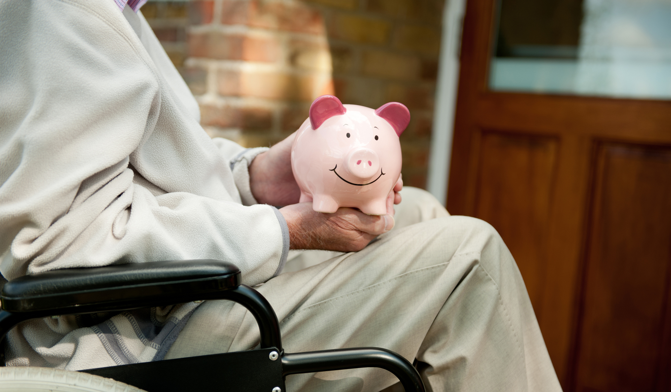 PIC - wheelchair user with piggy bank