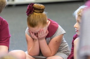 Young school girl with her head in her hands