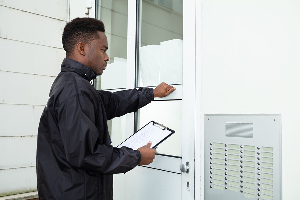 PIC - man with clipboard knocking on a front door