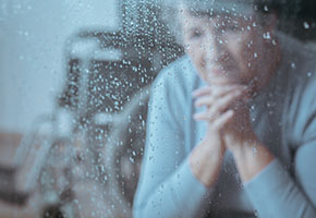 Older woman at rainy window