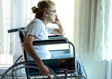 PIC - Older wheelchair user looking out of window